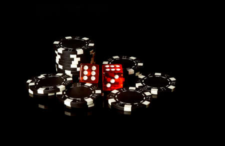 Black chips and red dice received as a result of winning. Craps is a dice game in which players bet on the outcomes of a pair of diceの写真素材