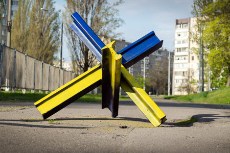 KYIV, UKRAINE - MAY 04, 2022: War of Russia against Ukraine. Anti-tank hedgehog on the sidewalk of the city of Kyiv painted under the national ensign of Ukraine in yellow and blueのeditorial素材