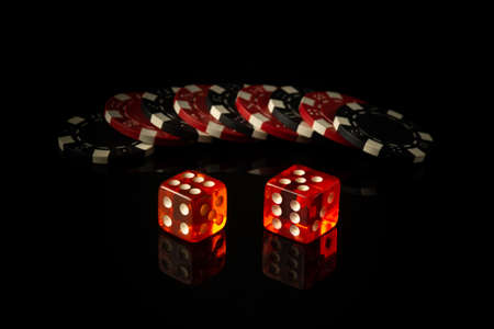 Dice and chips obtained from winnings while playing Craps. The idea of the game on a black...