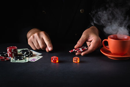 A player places a bet with chips on a winning combination when playing craps in a poker club. Luck or fortune in the casinoの写真素材