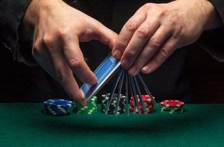 A player shuffles poker cards in a poker club against a green table with chips. Concept of playing...
