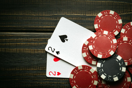 Playing cards with a winning combination of one pair and chips on a black vintage table in a poker...