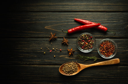 Peppers and spices on a black vintage table prepared for adding to food. Free space for menu or...