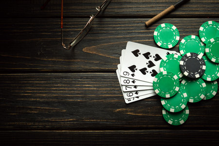 Playing cards with a winning combination of straight flush and chips on a black vintage table in a...