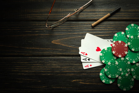 Playing cards with a winning combination of three of a kind or set on a black vintage table in a poker club. Winning in sports depends on luckの写真素材