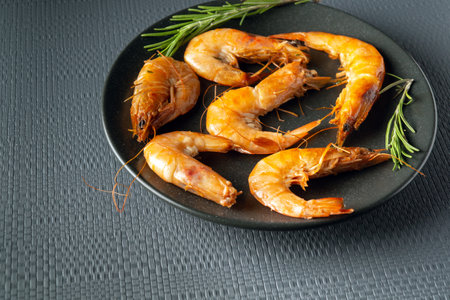 Caridea or boiled shrimps with rosemary in a bowl on a gray table. The idea of delicious dietary seafood for lunch or dinner.の写真素材