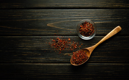 Spices in a wooden spoon and small bowl before adding to food for flavor. Cooking food on a vintage...