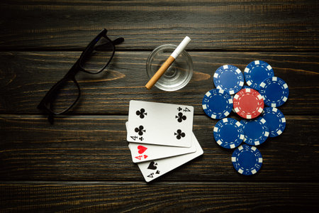Playing cards with a winning combination of three of a kind or set and glasses with a cigarette on a...