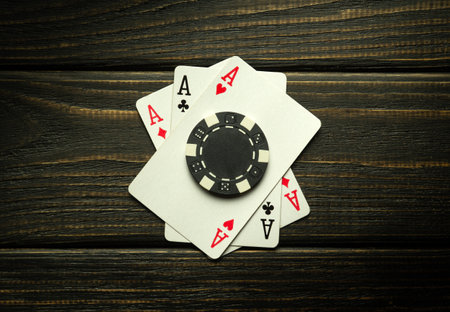 Poker game with three of a kind or set combination. Chips and cards on the black vintage table in poker club. successful win.の写真素材