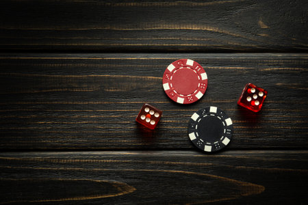 Poker chips and dice with a winning combination on a dark table. Luck in gambling depends on fortune.の写真素材