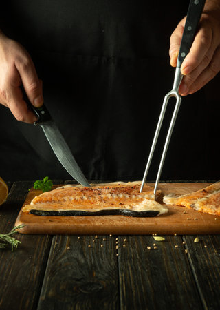 The chef is preparing a frozen trout steak on the kitchen table. Salmon is a delicious fish for...