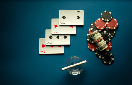 A popular poker game in America with a combination of two pairs. Chips with money and playing cards on a blue table in a poker club.の写真素材