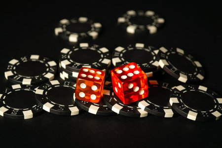 Dice and chips from winnings on the craps black table in the club. Fortune in the game depends on a successful combination in the game of dice.の写真素材