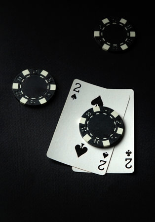 A successful combination of cards one pair and chips in a casino on a black table. Winning in the...