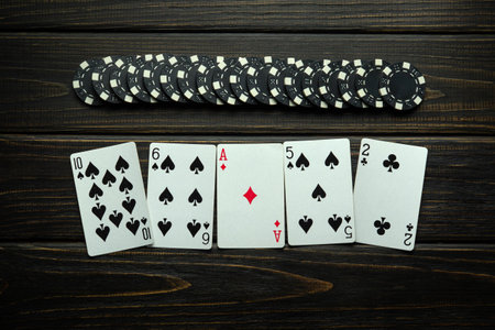 Win at the poker club. Combination of high card playing cards and chips on a vintage table. Space...