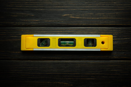 Construction level on vintage dark boards. Low key concept of construction and measuring a flat surface.の写真素材