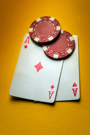 Poker chips and cards with a winning combination of one pair in a club on a yellow table. Fortune...