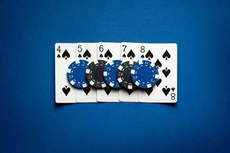 Playing cards and chips on a blue table in a casino. Concept of a successful straight flush combination in a poker game. Lucky win.の写真素材
