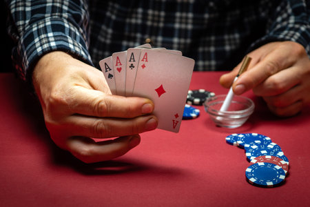 Playing cards in the hand of a gambler with a lucky combination of four of a kind or quads. A lucky...