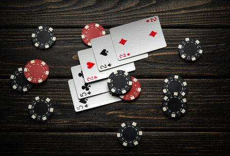 Chips and playing cards with a winning combination of full house or full boat are scattered...