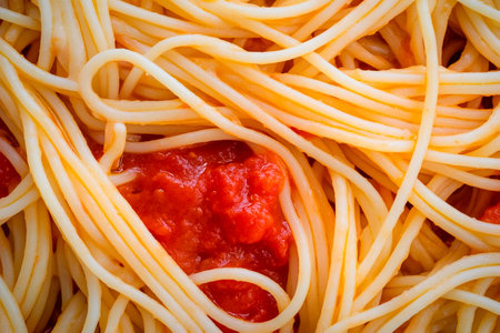 Twirls of fresh spaghetti laid elegantly, coated in a rich red sauce that beckons for a fork. This inviting dish captures the essence of comfort food, perfect for sharing.の素材