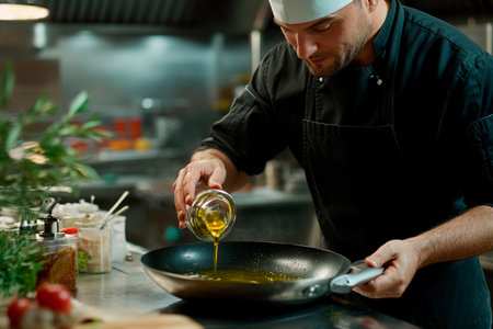Under warm, ambient lighting, a skilled chef pours oil into a sizzling pan, poised to create a culinary masterpiece. Fresh ingredients surround him, showcasing his dedication to high-quality cooking.の素材