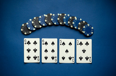 Blue and black chips are neatly stacked beside four visible cards, two of which show matching pairs.の写真素材