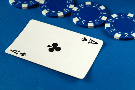 A close-up view showcases an ace of clubs card placed on a surface with several blue poker chips...