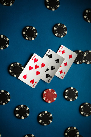 On the card table are three sevens and the playing chips from winning poker, displaying two pairs of cards and a lively perfect atmosphere for an evening of gaming.の写真素材