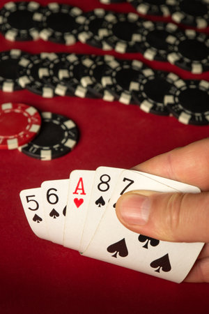 In a lively casino environment, a hand reveals a strong poker hand featuring an ace, seven, and five...