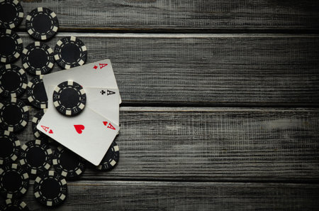 On a gray vintage table a successful combination of playing cards three of a kind or set and black...