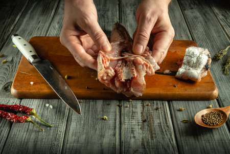 A person holds a piece of raw meat above a wooden cutting board, surrounded by a knife and various...