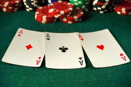 A poker table is set with three aces displayed prominently. Surrounding the cards are numerous...