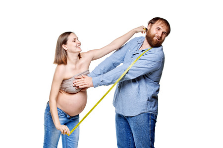 stout man with measure tape and pregnant woman on a white background, isolated on a white backgroundの写真素材