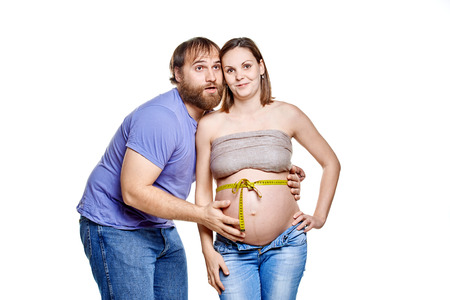 stout man with measure tape and pregnant woman on a white background, isolated on a white backgroundの写真素材