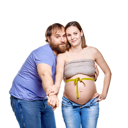 stout man with measure tape and pregnant woman on a white background, isolated on a white backgroundの写真素材