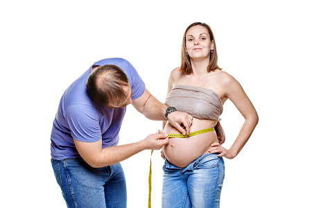 stout man with measure tape and pregnant woman on a white background, isolated on a white backgroundの写真素材