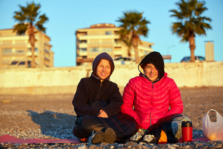 smiling girls on sea beach at the sunriseの写真素材