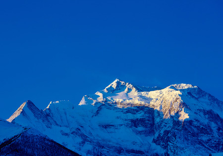 beautifull cloudy sunrise in the mountains with snow ridgeの写真素材