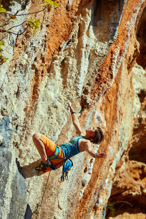 female rock climber climbs on a rocky wallの写真素材