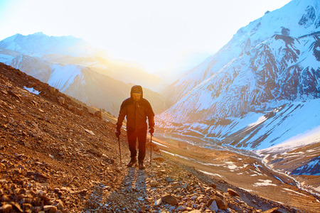hiker at the top of a pass with backpacks meeting the sunrise in the mountainsの写真素材