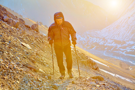 hiker at the top of a pass with backpacks meeting the sunrise in the mountainsの写真素材