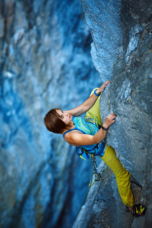 female rock climber climbs on a rocky wallの写真素材