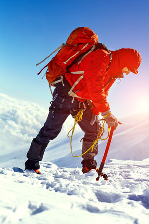 hiker at the top of a pass with backpacks meeting the sunrise in the mountainsの写真素材