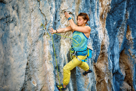female rock climber climbs on a rocky wall. Cidtibi Canyon, Geyikbayiri, Turkey.の写真素材