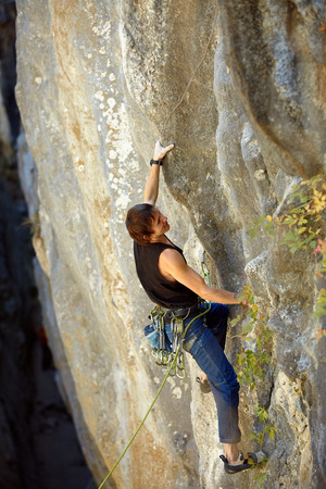 rock climber climbs on a rocky wallの写真素材