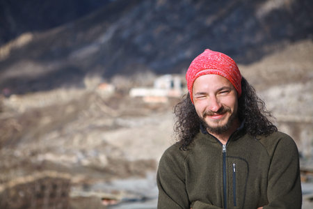 male traveller in the Himalaya mountains. man looks squinting and smiling