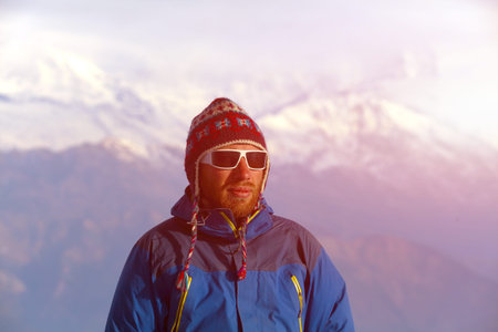 hiker at the top of a pass meeting the sunrise in the mountains