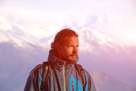 hiker at the top of a pass meeting the sunrise in the mountains