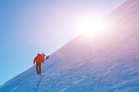 hikers at the top of a pass with backpacks meeting the sunrise in the mountainsの写真素材